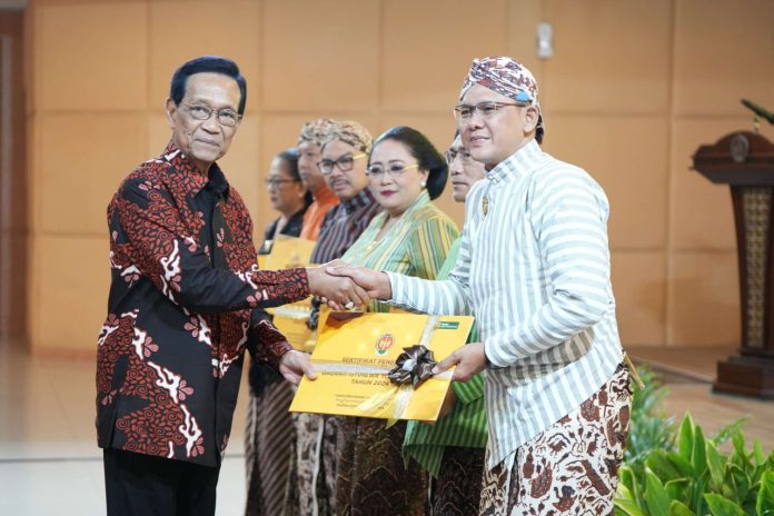 Gubernur DIY Sri Sultan HB X (kiri) saat menyerahkan sertifikat Warisan Budaya Takbenda kepada Wabup Sleman Danang Maharsa (kanan). (Foto: Humas Sleman)