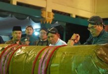 Bupati Bantul Abdul Halim Muslih (kanan) saat memotong lemper raksasa dalam tradisi adat Rebo Pungkasan di Wonokromo, Pleret, Bantul, Selasa (19/8/2025). (Foto: Humas Pemkab Bantul)