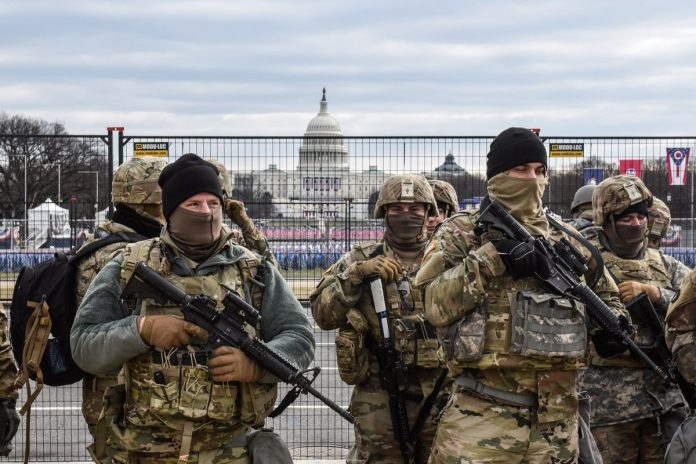 Anggota Garda Nasional berpatroli di depan National Mall pada 19 Januari 2021 di Washington DC. Keamanna diperketat jelang hari pelantikan Joe Biden, di tengah ancaman keamanan menyusul kerusuhan di Gedung Capitol pada 6 Januari.(AFP PHOTO/GETTY IMAGES NORTH AMERICA/STEPHANIE KEITH