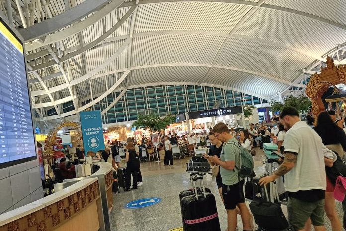 Para wisatawan di Bandara Internasional Ngurah Rai, Bali memonitor perkembangan jadwal penerbangan, Senin (7/7/2025).(KOMPAS.com/NI KETUT SUDIANI