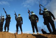 Sejumlah milisi kelompok Hamas berdiri menjelang penyerahan jenazah empat sandera Israel di Khan Yunis, Gaza selatan, 20 Februari 2025. (AFP/EYAD BABA)