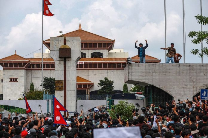Para peserta demo Nepal berorasi di depan Gedung Parlemen di Kathmandu, Senin (8/9/2025). Demo ini menewaskan sedikitnya 19 orang. Kasus korupsi hingga larangan media sosial jadi landasan massa turun ke jalan.(AFP/PRABIN RANABHAT) Para peserta demo Nepal berorasi di depan Gedung Parlemen di Kathmandu, Senin (8/9/2025). Demo ini menewaskan sedikitnya 19 orang. Kasus korupsi hingga larangan media sosial jadi landasan massa turun ke jalan.(AFP/PRABIN RANABHAT)