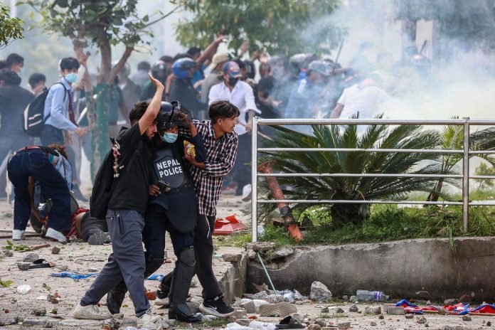 Peserta demo Nepal menggotong pengunjuk rasa yang terluka dalam demonstrasi di luar Gedung Parlemen di Kathmandu, Senin (8/9/2025). Demo Nepal pecah setelah pemerintah melarang 26 media sosial yang belum terdaftar, dan massa jengah dengan korupsi yang merajalela di kalangan pejabat.(AFP/PRABIN RANABHAT)